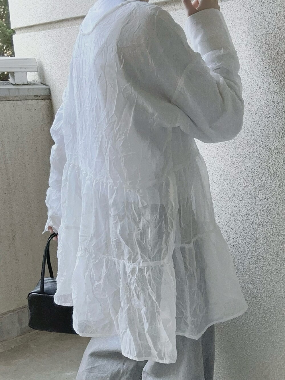 ホワイト系のシャツ/ブラウス、グレー系のデニムパンツ、ブラック系のボストンバッグを着用したレディースの春コーディネートの4枚目の写真