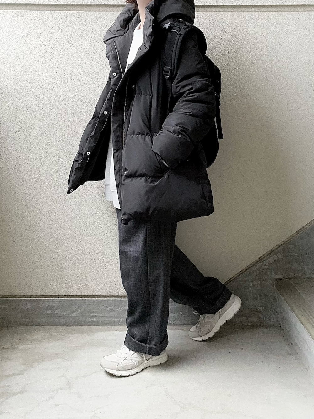 ブラック系のダウンジャケット/コート、ベージュ系のスウェット、グレー系のスラックスを着用したレディースの冬コーディネートの2枚目の写真