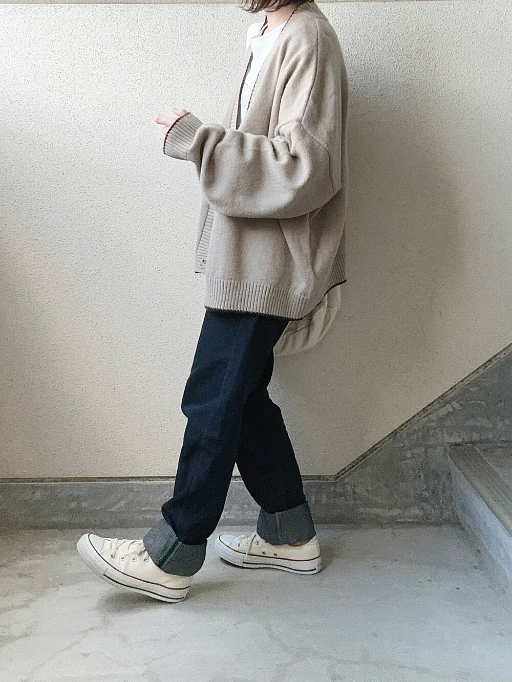 ベージュ系のカーディガン/ボレロ、ホワイト系のTシャツ/カットソー、ホワイト系のショルダーバッグを着用したレディースの冬コーディネートの2枚目の写真