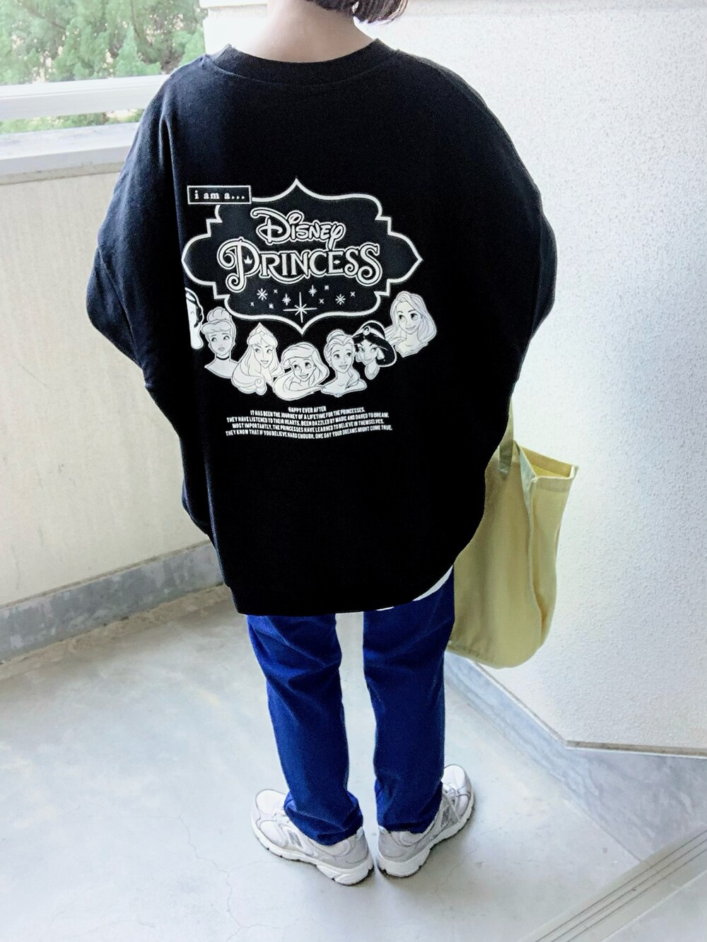 ブラック系のスウェット、ブルー系のスウェットパンツ、イエロー系のトートバッグを着用したレディースの春コーディネートの3枚目の写真