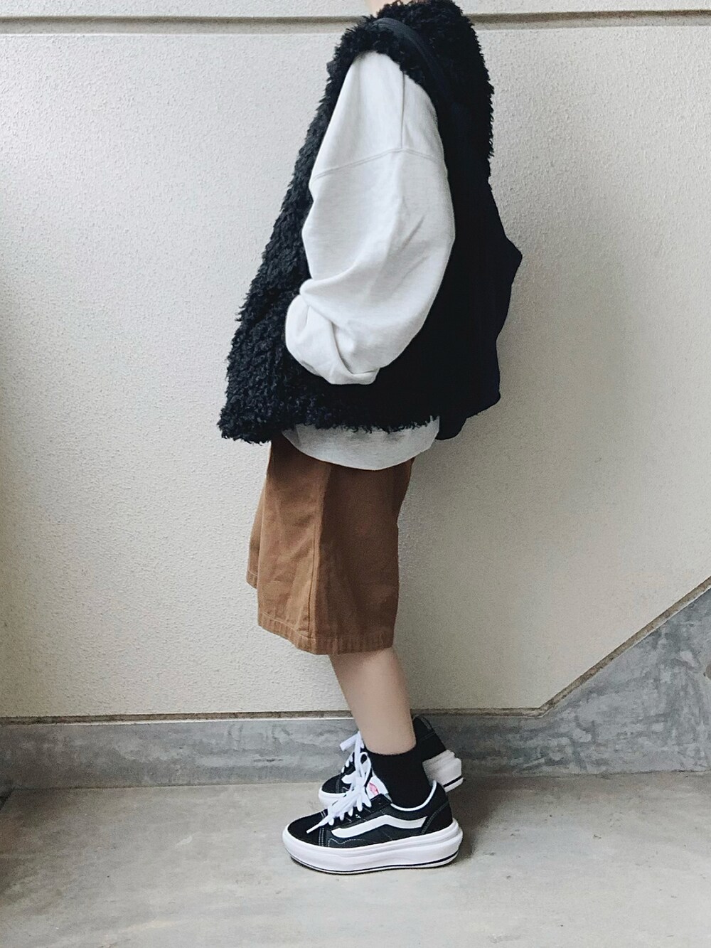 ブラック系のベスト、ブラック系のスニーカー、ブラウン系のその他パンツを着用したレディースの秋コーディネートの2枚目の写真