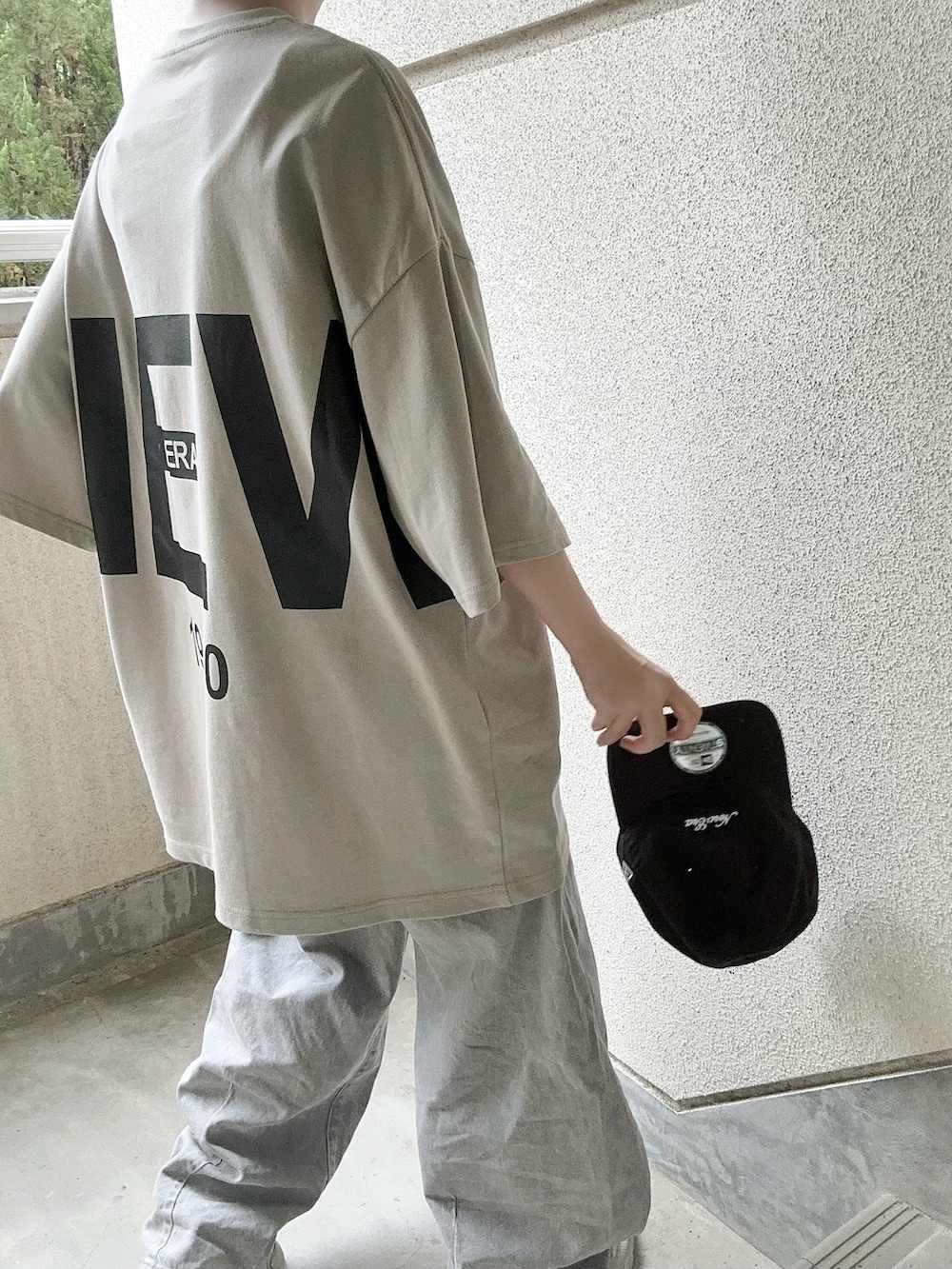 ベージュ系のTシャツ/カットソー、ブラック系のキャップを着用したレディースの夏コーディネートの2枚目の写真