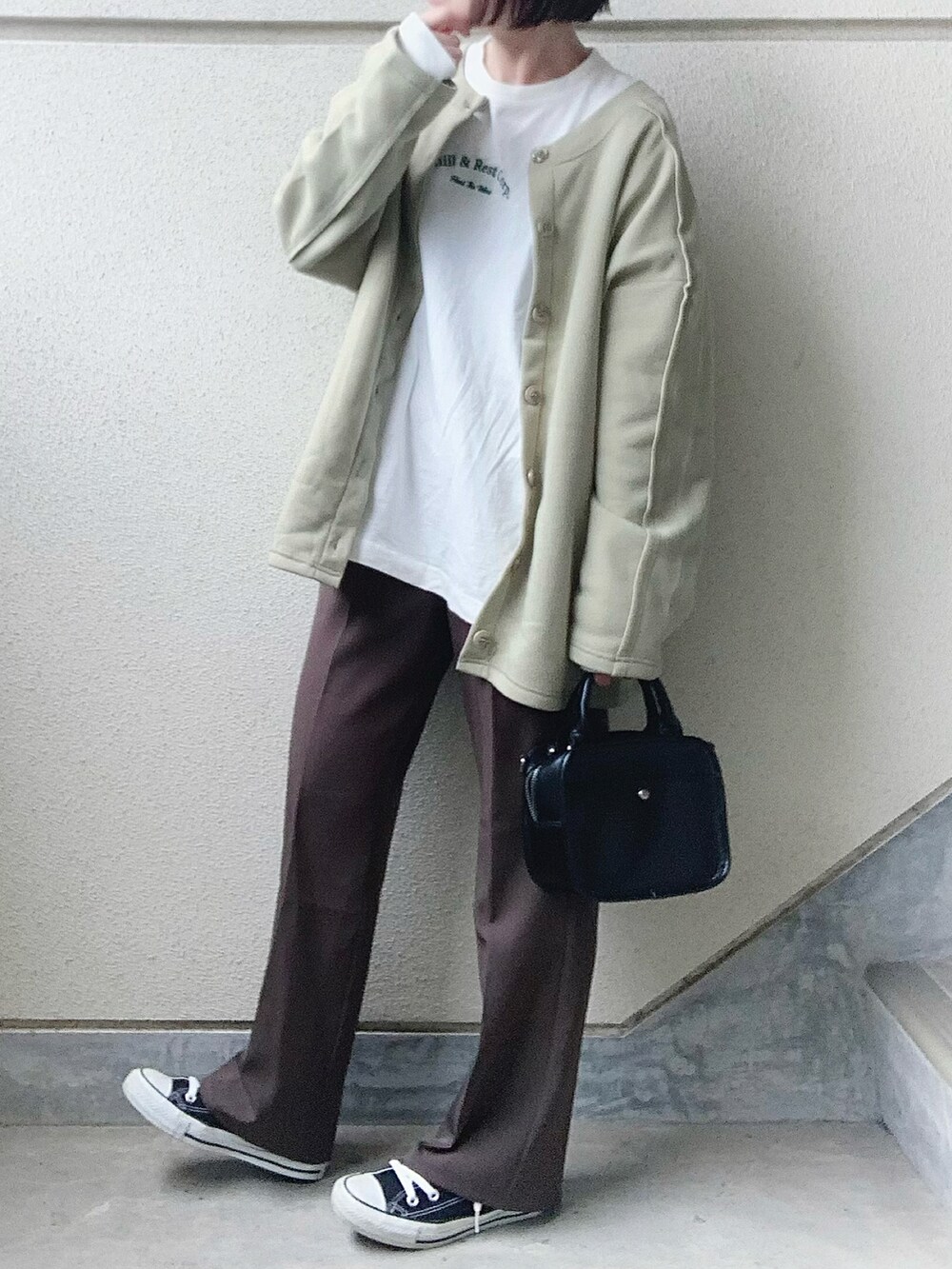 グリーン系のカーディガン/ボレロ、ホワイト系のTシャツ/カットソー、グレー系のスラックスを着用したレディースの冬コーディネートの4枚目の写真