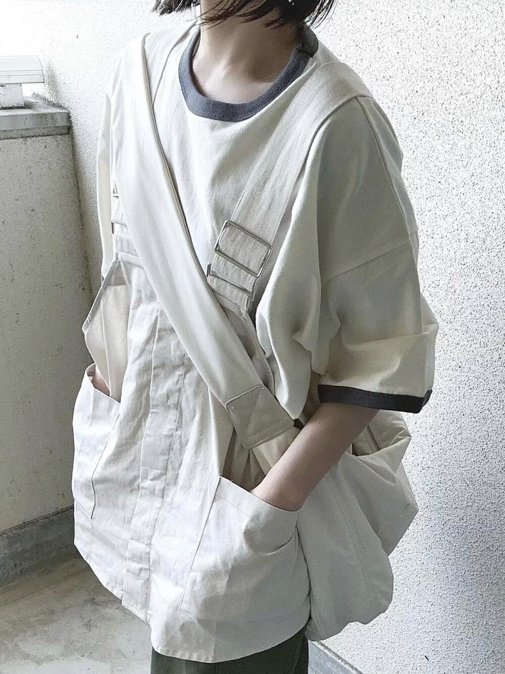 ホワイト系のベスト、グレー系のTシャツ/カットソー、グリーン系のカーゴパンツを着用したレディースの春コーディネートの4枚目の写真