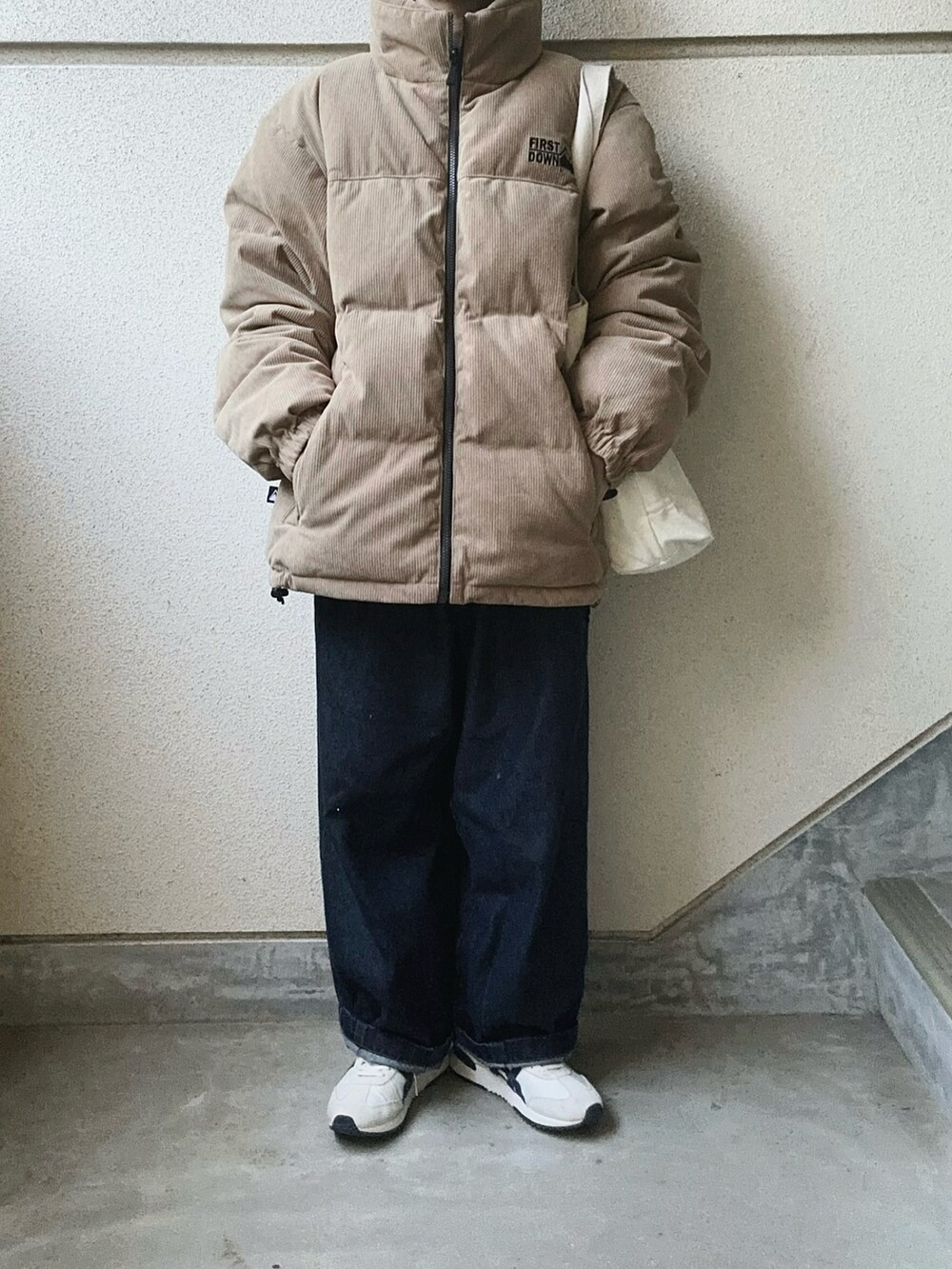 ベージュ系のダウンジャケット/コートを着用したレディースの秋コーディネートの2枚目の写真