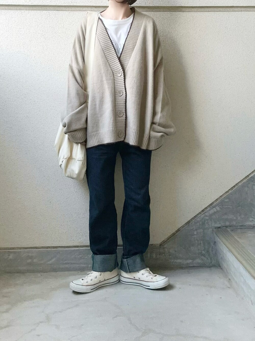 ベージュ系のカーディガン/ボレロ、ホワイト系のTシャツ/カットソー、ホワイト系のショルダーバッグを着用したレディースの冬コーディネートの4枚目の写真