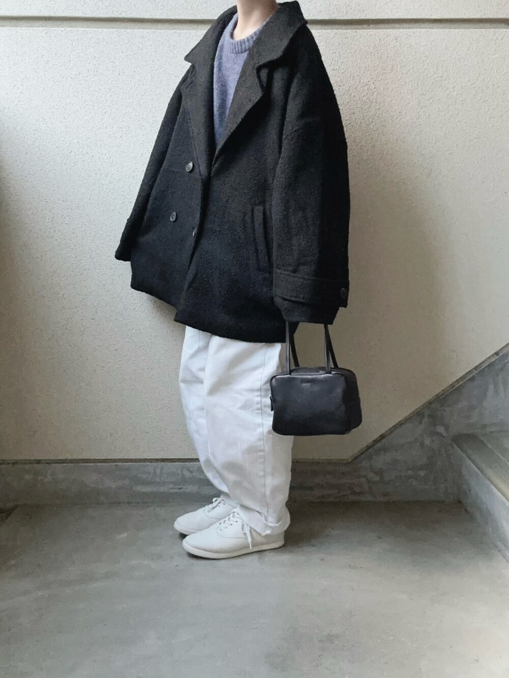 ブラック系のピーコート、ブラック系のボストンバッグ、ブルー系のニット/セーターを着用したレディースの冬コーディネートの4枚目の写真