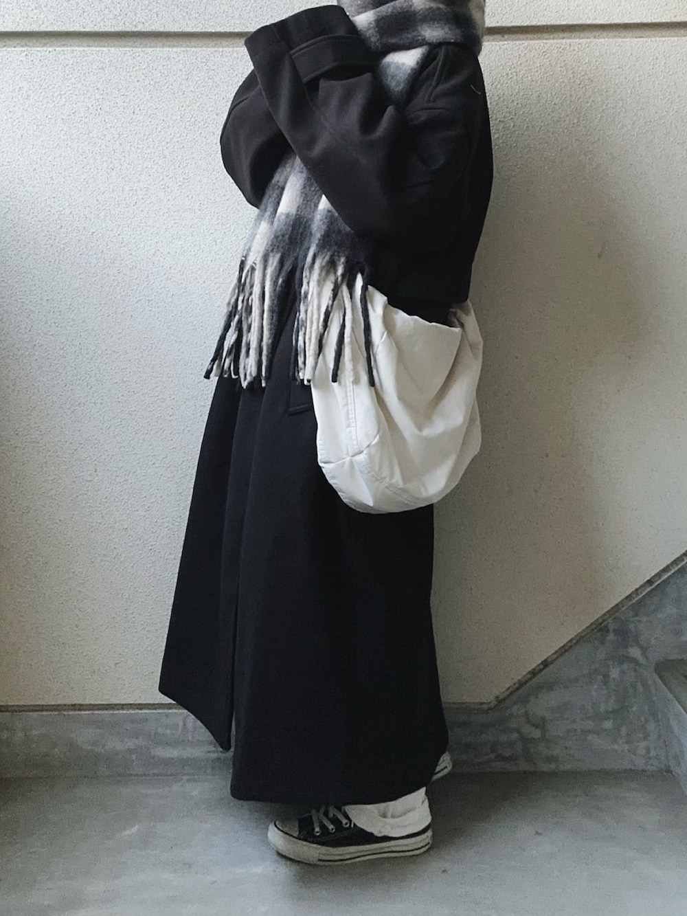 ブラック系のトレンチコート、ブラック系のマフラーを着用したレディースの冬コーディネートの4枚目の写真