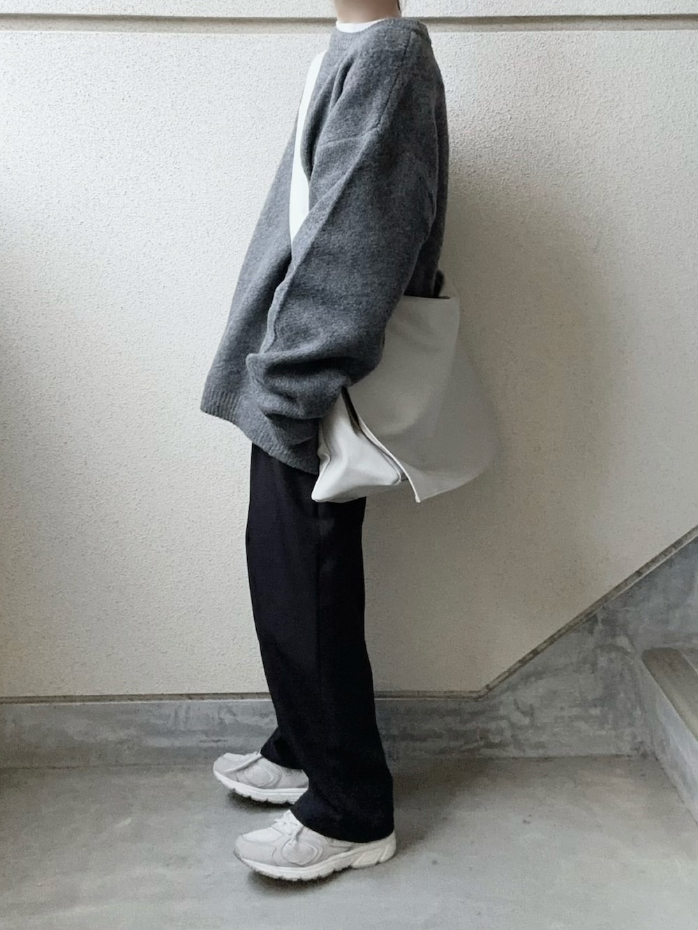 グレー系のニット/セーター、グレー系のショルダーバッグを着用したレディースの冬コーディネートの5枚目の写真