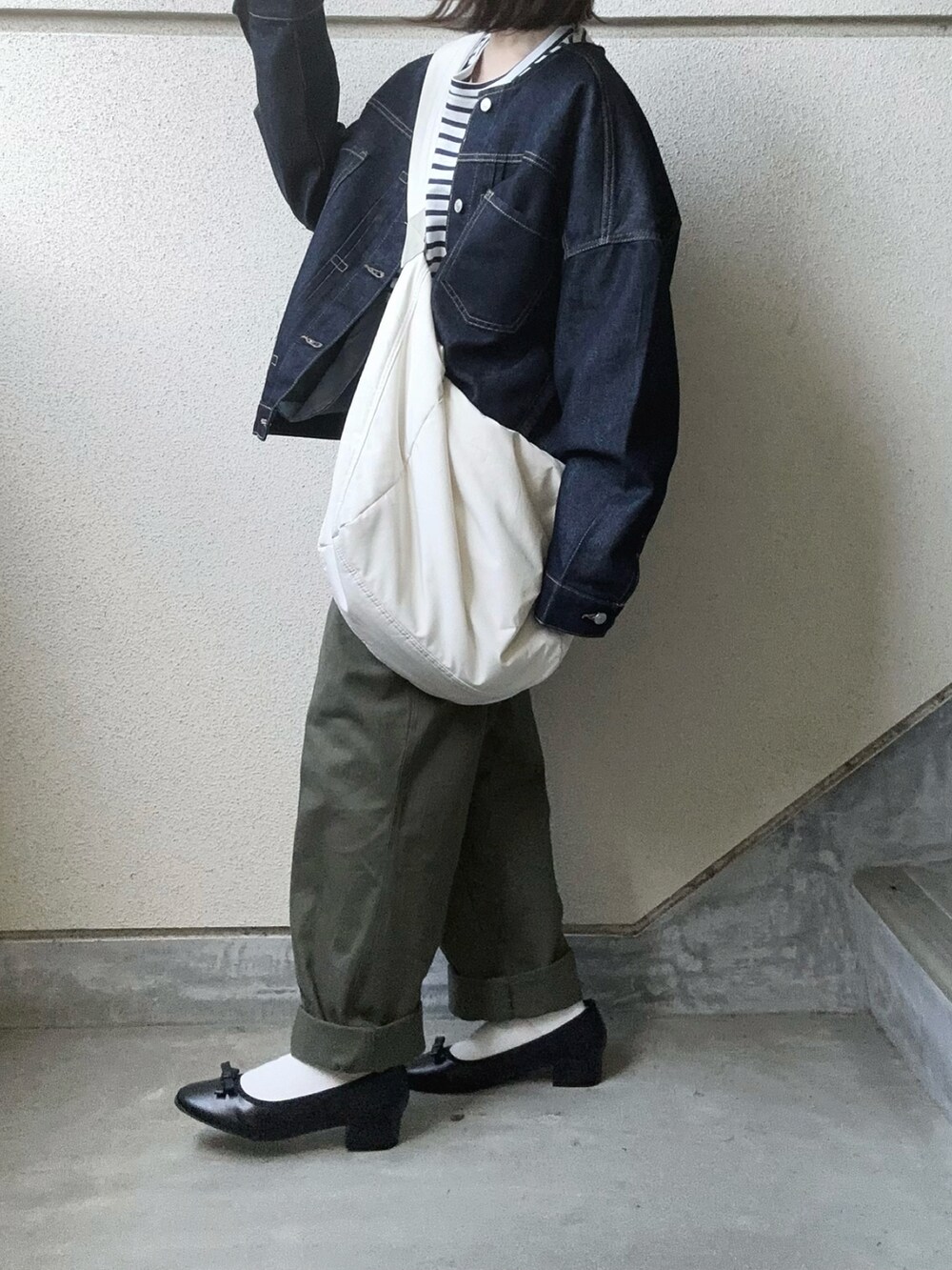 ブラック系のバレエシューズ、ブルー系のデニムジャケット、グリーン系のチノパンツを着用したレディースの夏コーディネートの2枚目の写真