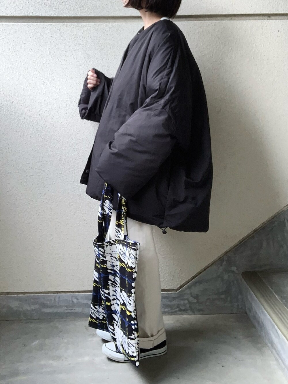 ブラック系のその他アウター、ベージュ系のスウェット、ホワイト系のデニムパンツを着用したレディースの冬コーディネートの4枚目の写真