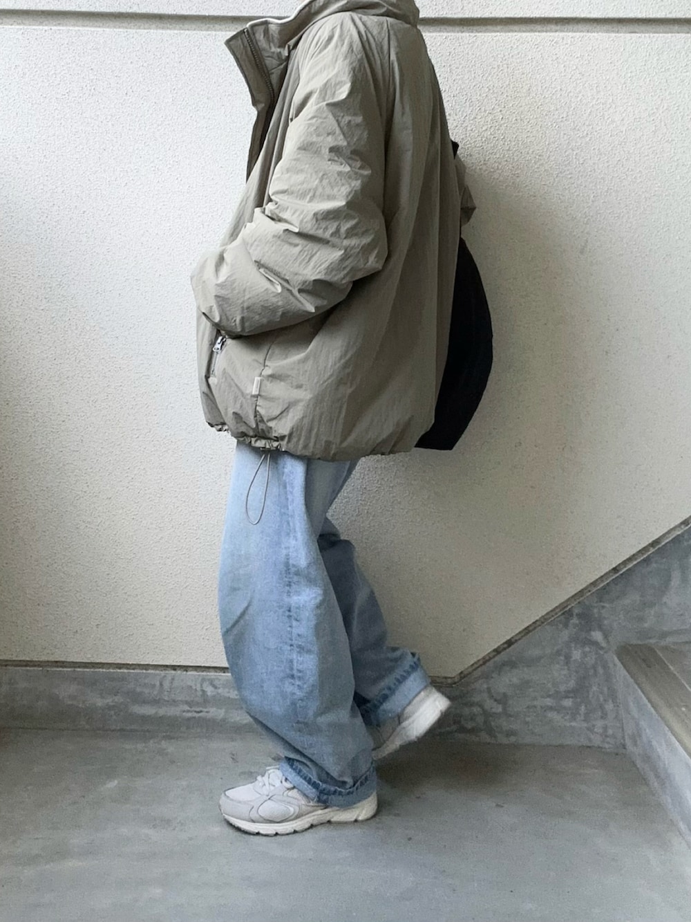 グリーン系のブルゾン、ブルー系のデニムパンツを着用したレディースの秋コーディネートの4枚目の写真