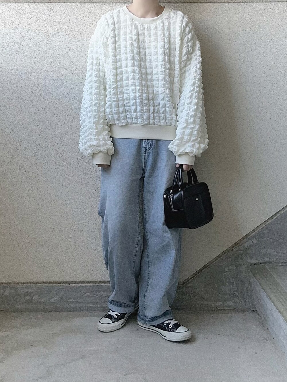 ホワイト系のTシャツ/カットソー、ブルー系のデニムパンツ、ブラック系のスニーカーを着用したレディースの冬コーディネートの2枚目の写真