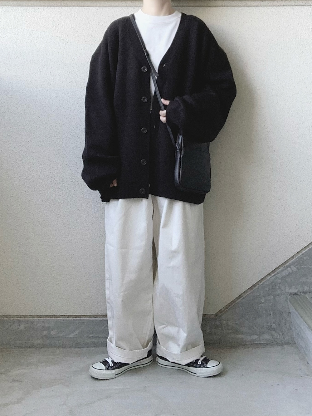 ベージュ系のチノパンツ、ブラック系のカーディガン/ボレロ、ホワイト系のTシャツ/カットソーを着用したレディースの秋コーディネートの5枚目の写真