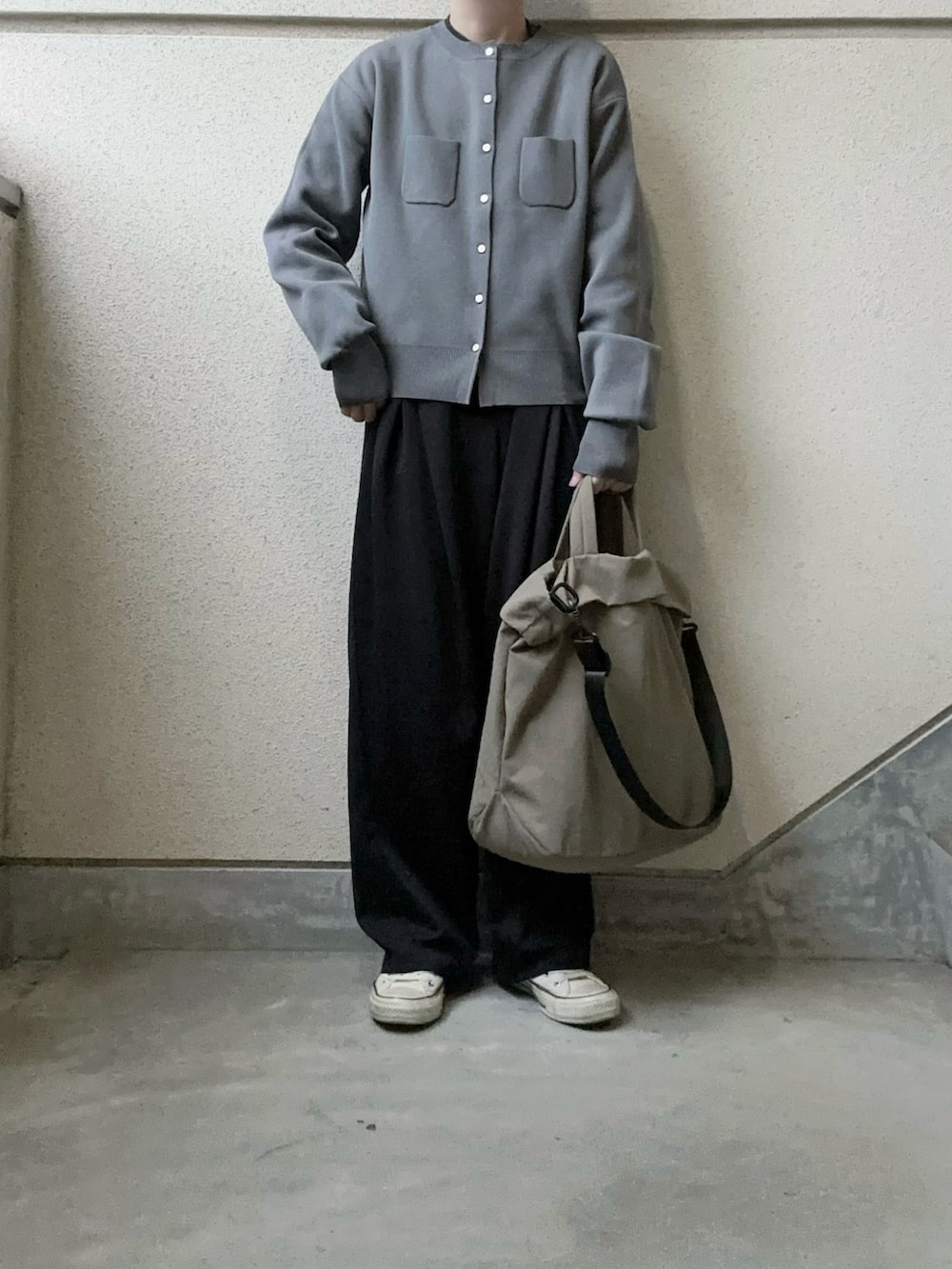 グレー系のカーディガン/ボレロ、ブラック系のスラックス、グリーン系のトートバッグを着用したレディースの冬コーディネートの2枚目の写真