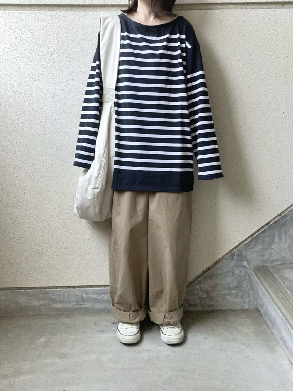 ブルー系のTシャツ/カットソー、ベージュ系のチノパンツを着用したレディースの春コーディネートの3枚目の写真