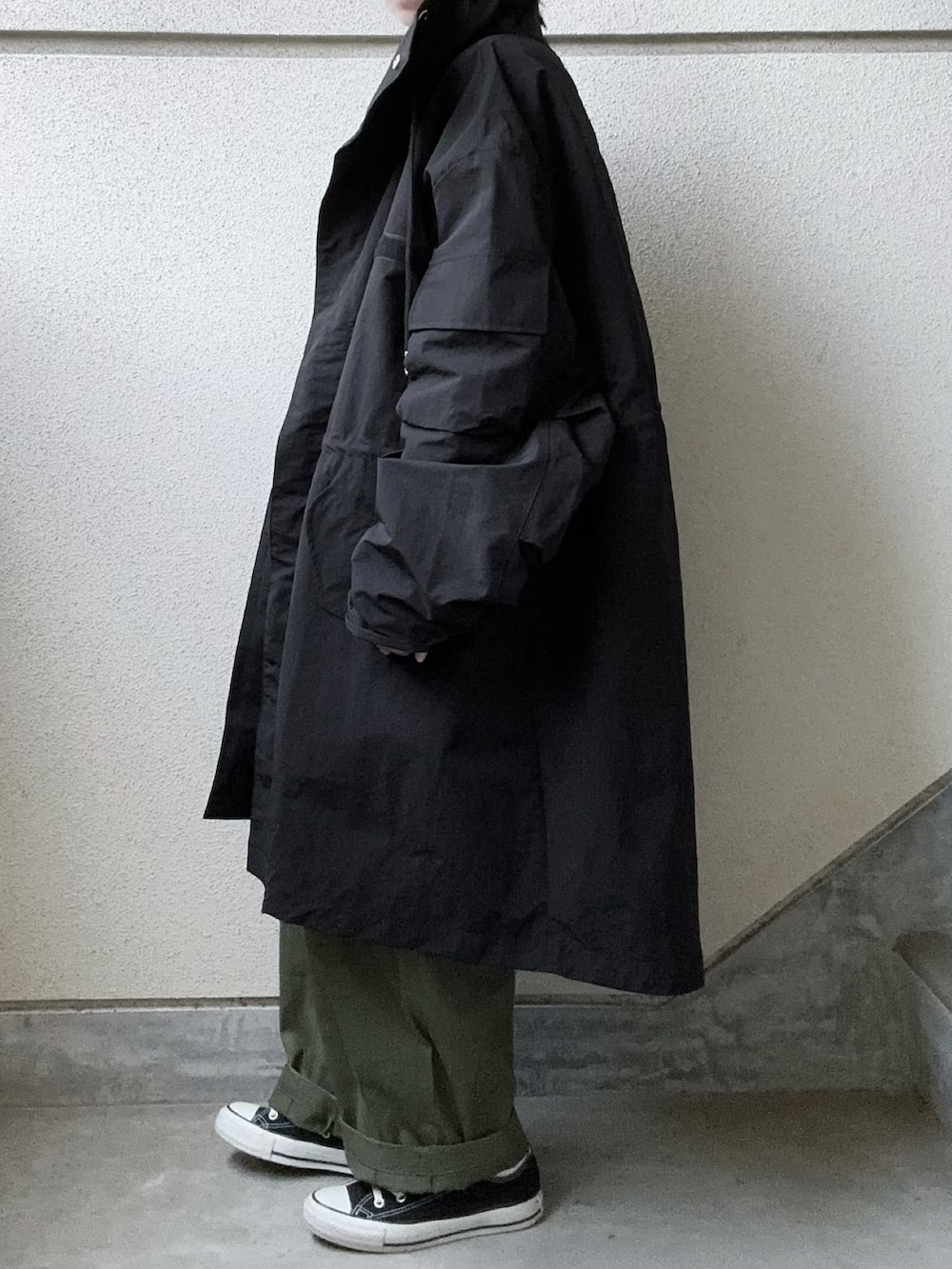 ブラック系のモッズコート、グリーン系のカーゴパンツ、ブラック系のニット/セーターを着用したレディースの秋コーディネートの4枚目の写真