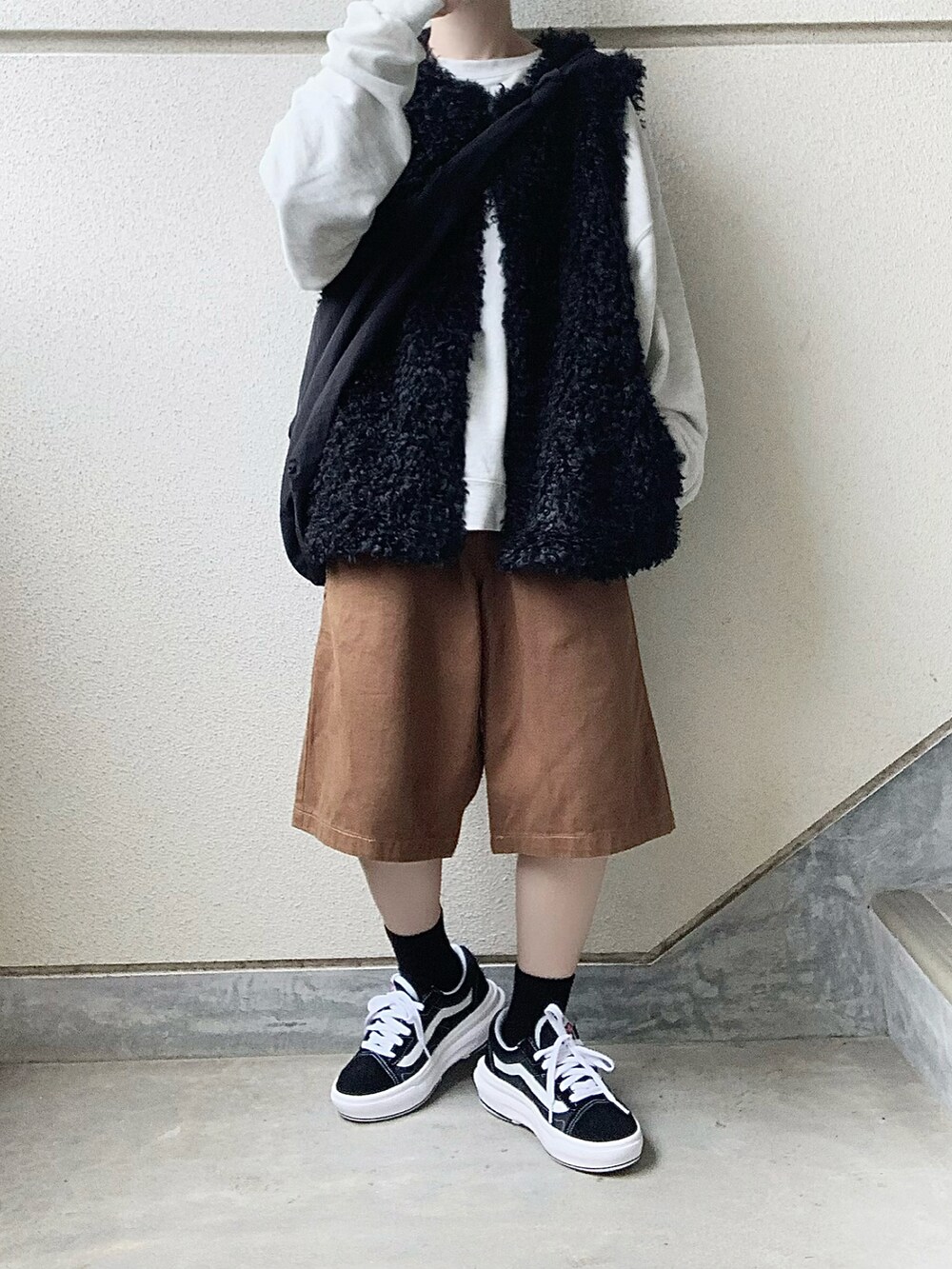 ブラック系のベスト、ブラック系のスニーカー、ブラウン系のその他パンツを着用したレディースの秋コーディネートの3枚目の写真