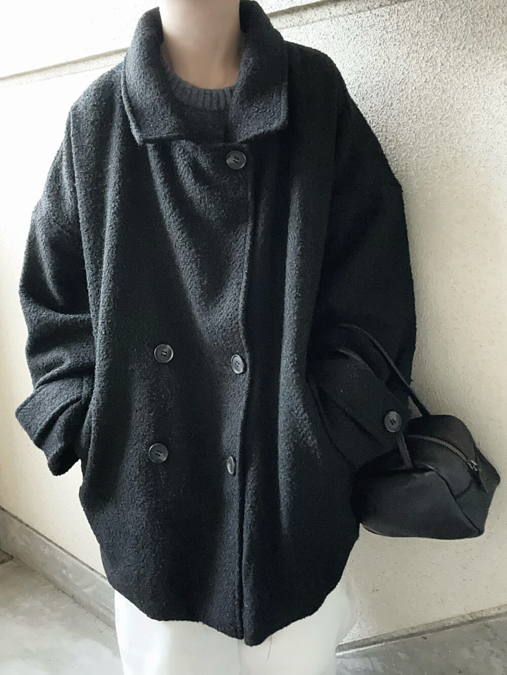 ブラック系のピーコート、ブラック系のボストンバッグ、ブルー系のニット/セーターを着用したレディースの冬コーディネートの5枚目の写真