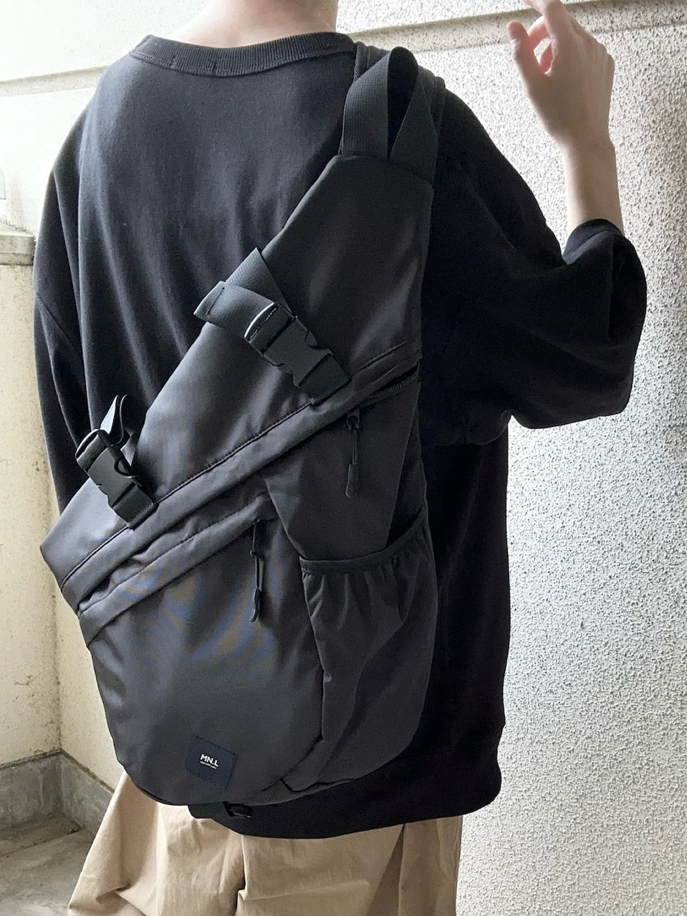 ブラック系のボディバッグ/ウエストポーチ、ベージュ系のチノパンツを着用したレディースの夏コーディネートの4枚目の写真