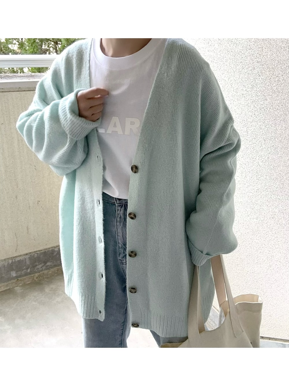 ブルー系のカーディガン/ボレロ、ホワイト系のTシャツ/カットソーを着用したレディースの冬コーディネートの2枚目の写真