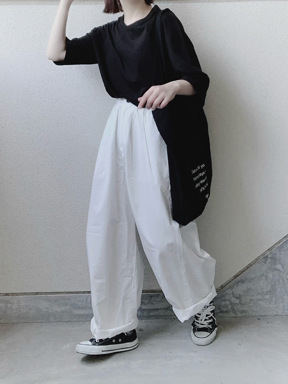ブラック系のTシャツ/カットソー、ホワイト系のチノパンツ、ブラック系のトートバッグを着用したレディースの夏コーディネートの2枚目の写真