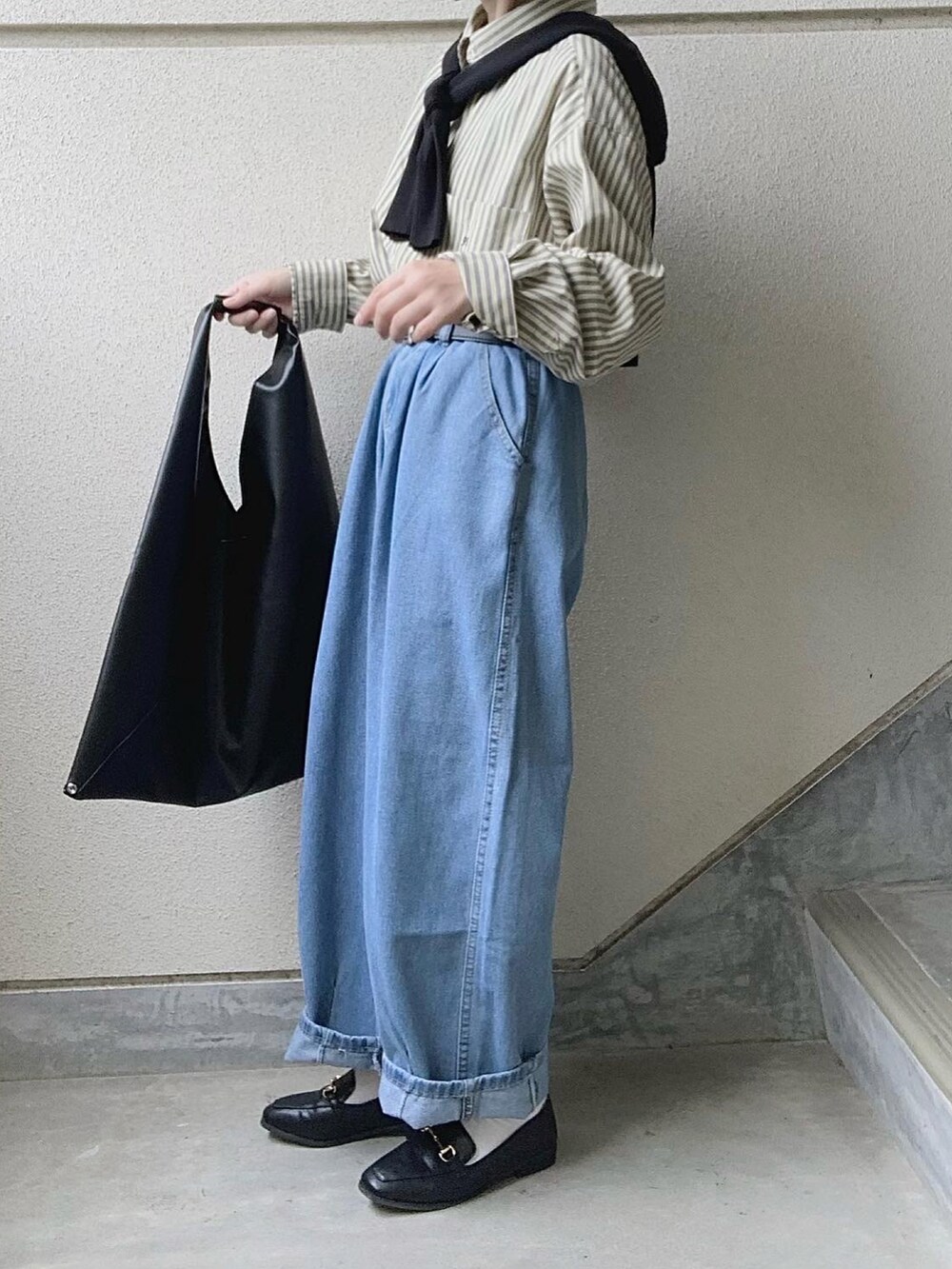 ブラック系のトートバッグ、ブルー系のデニムパンツ、イエロー系のシャツ/ブラウスを着用したレディースの秋コーディネートの3枚目の写真