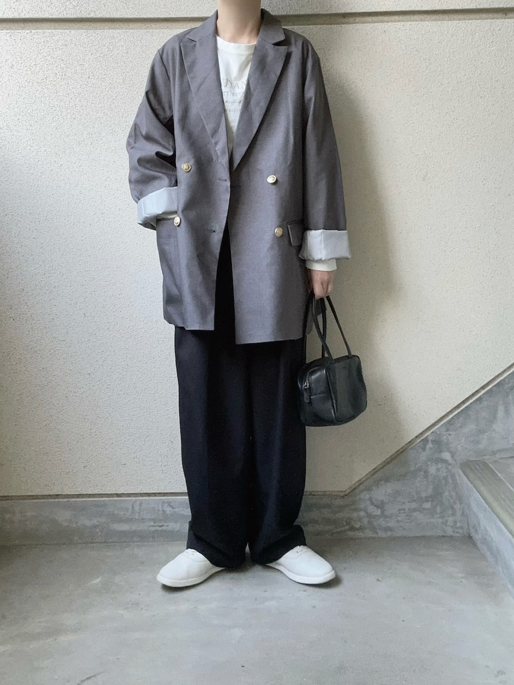 グレー系のテーラードジャケット、ブラック系のボストンバッグを着用したレディースの秋コーディネートの2枚目の写真