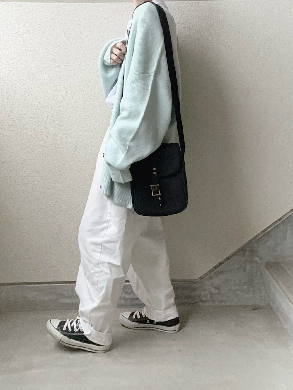 ブルー系のカーディガン/ボレロ、ホワイト系のTシャツ/カットソー、ブラック系のショルダーバッグを着用したレディースの冬コーディネートの3枚目の写真