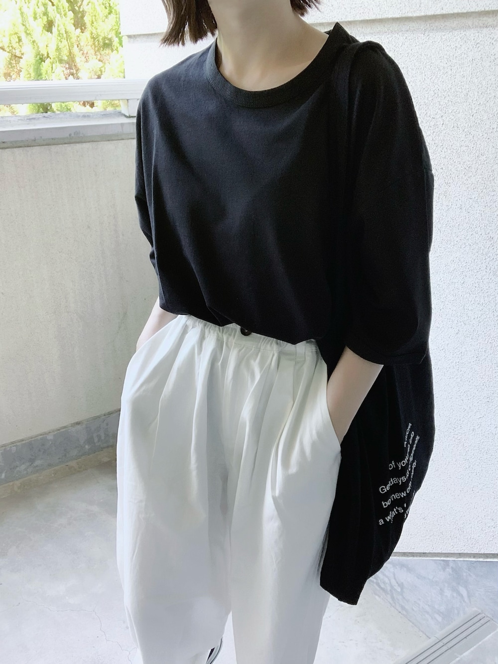 ブラック系のTシャツ/カットソー、ホワイト系のチノパンツ、ブラック系のトートバッグを着用したレディースの夏コーディネートの3枚目の写真