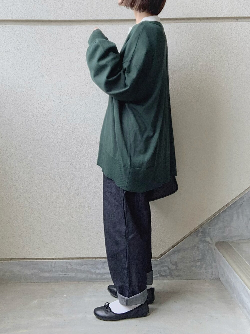 グリーン系のカーディガン/ボレロ、ブルー系のデニムパンツ、ブラック系のバレエシューズを着用したレディースの春コーディネートの2枚目の写真