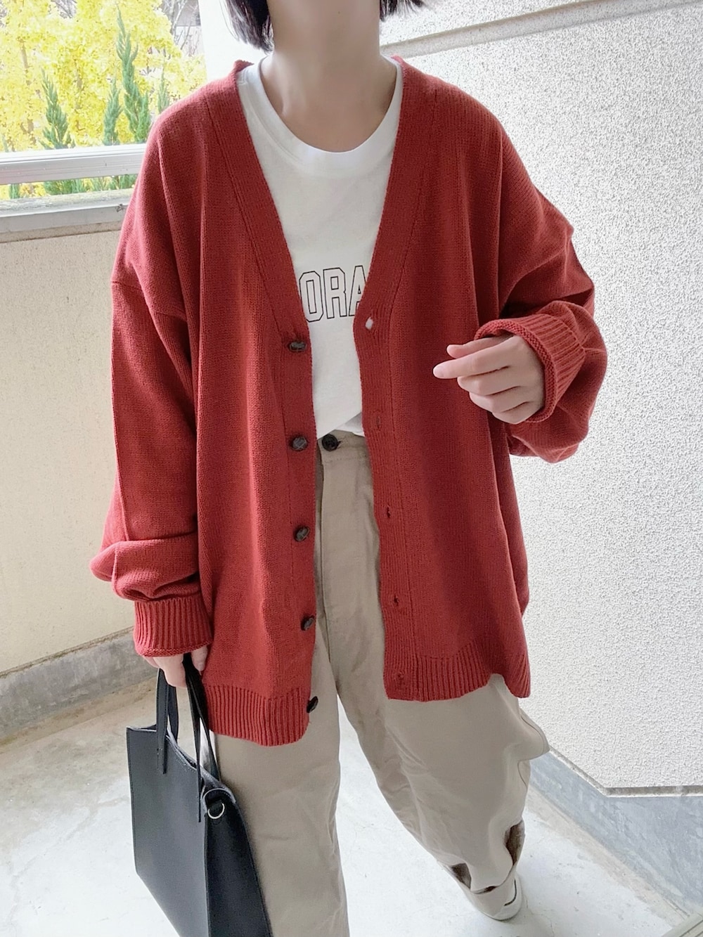 オレンジ系のカーディガン/ボレロ、ホワイト系のTシャツ/カットソー、ベージュ系のその他パンツを着用したレディースの冬コーディネートの2枚目の写真