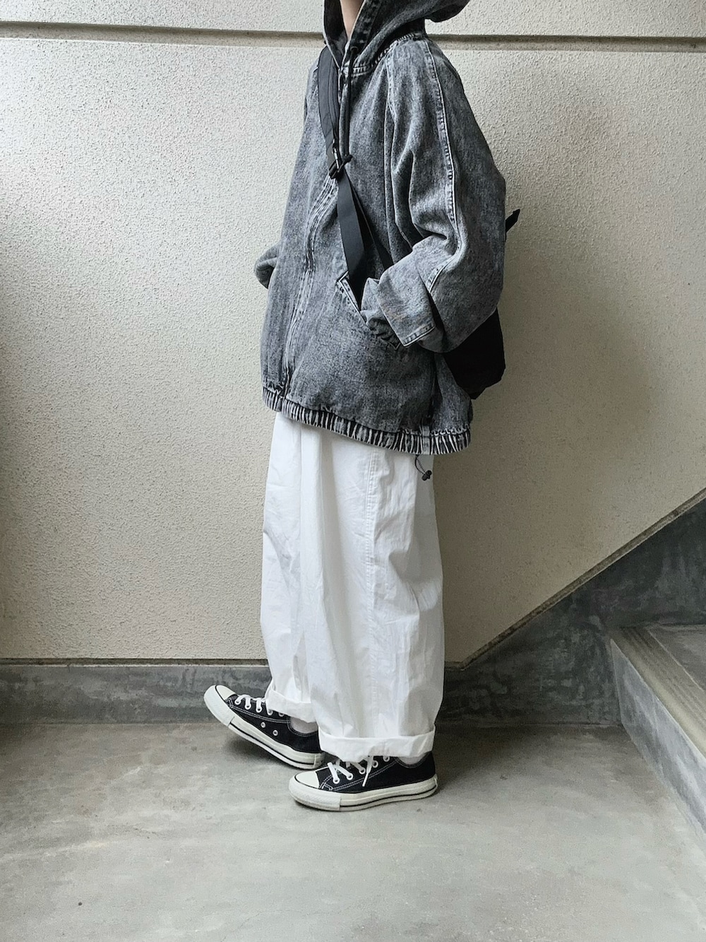 ブラック系のブルゾン、ブラック系のボディバッグ/ウエストポーチ、ホワイト系のチノパンツを着用したレディースの春コーディネートの5枚目の写真