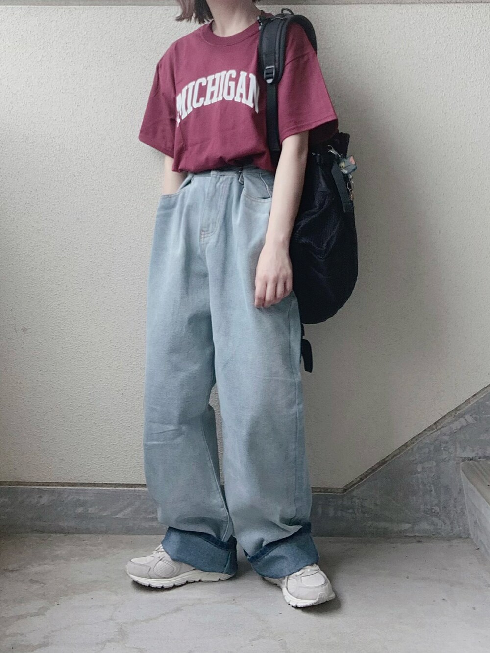 レッド系のTシャツ/カットソー、ブルー系のデニムパンツ、グレー系のスニーカーを着用したレディースの夏コーディネートの3枚目の写真