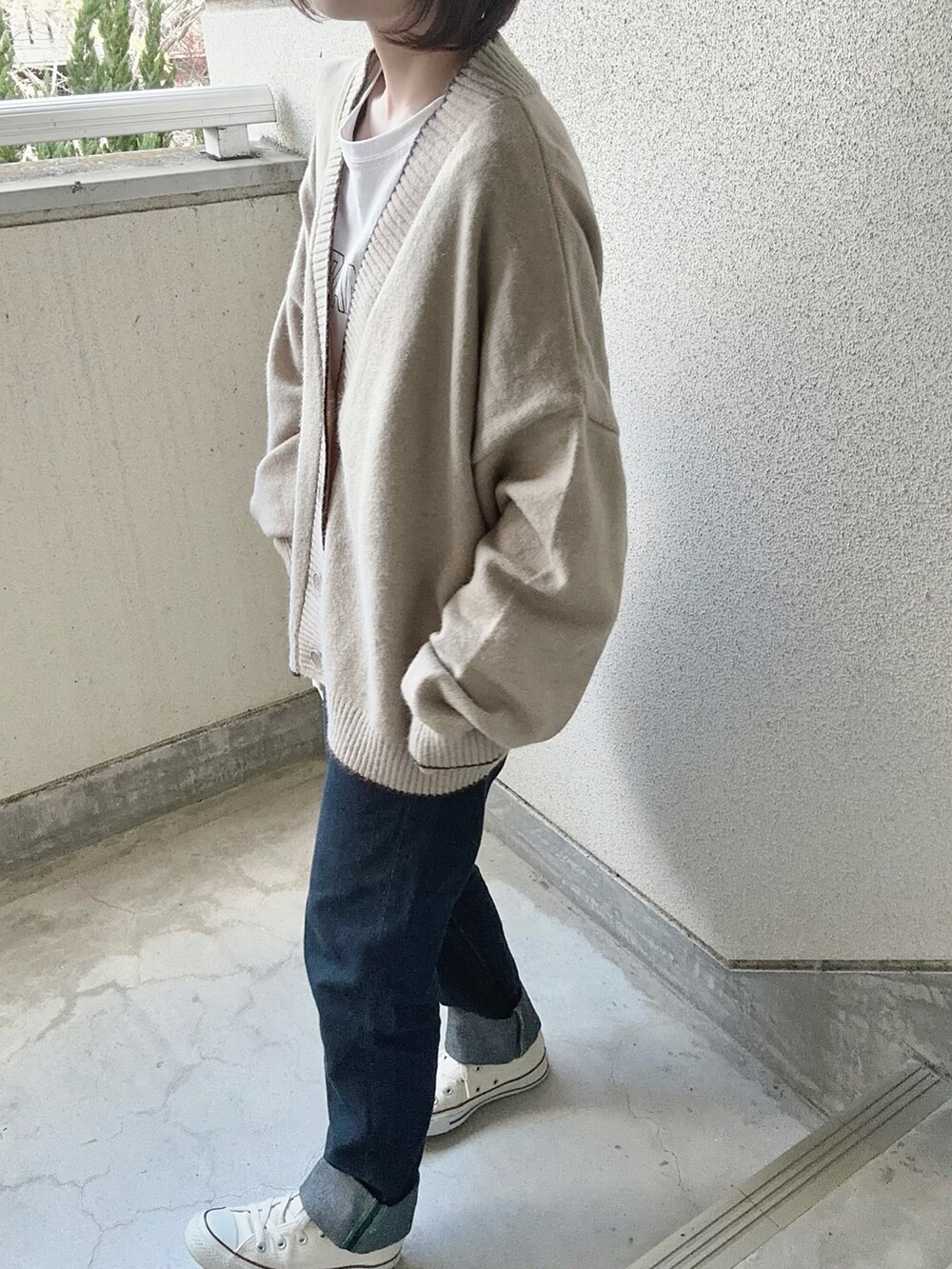 ベージュ系のカーディガン/ボレロ、ホワイト系のTシャツ/カットソー、ホワイト系のショルダーバッグを着用したレディースの冬コーディネートの5枚目の写真