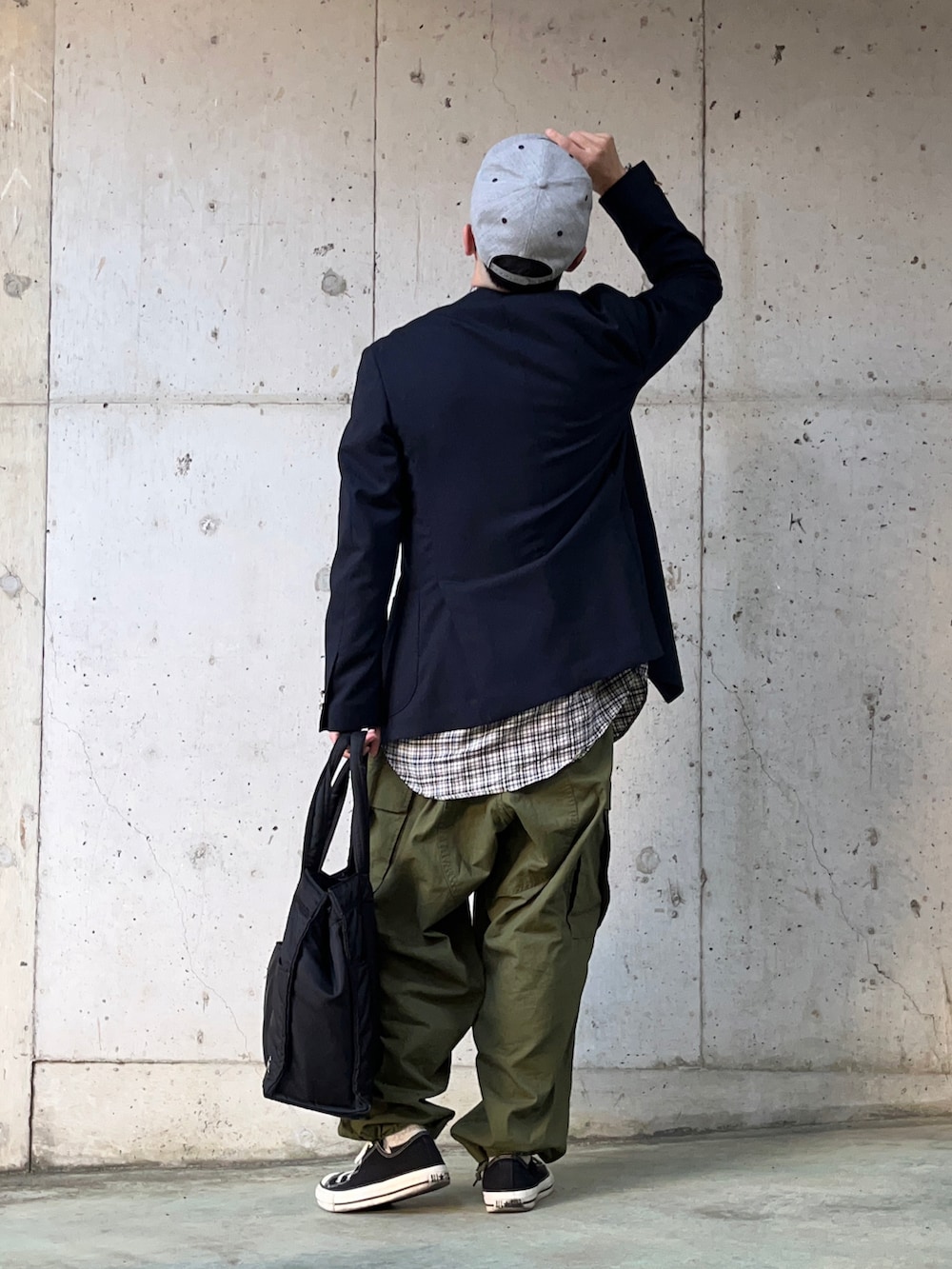 ブルー系のテーラードジャケット、グリーン系のカーゴパンツ、ブラック系のスニーカーを着用したメンズの春コーディネートの2枚目の写真