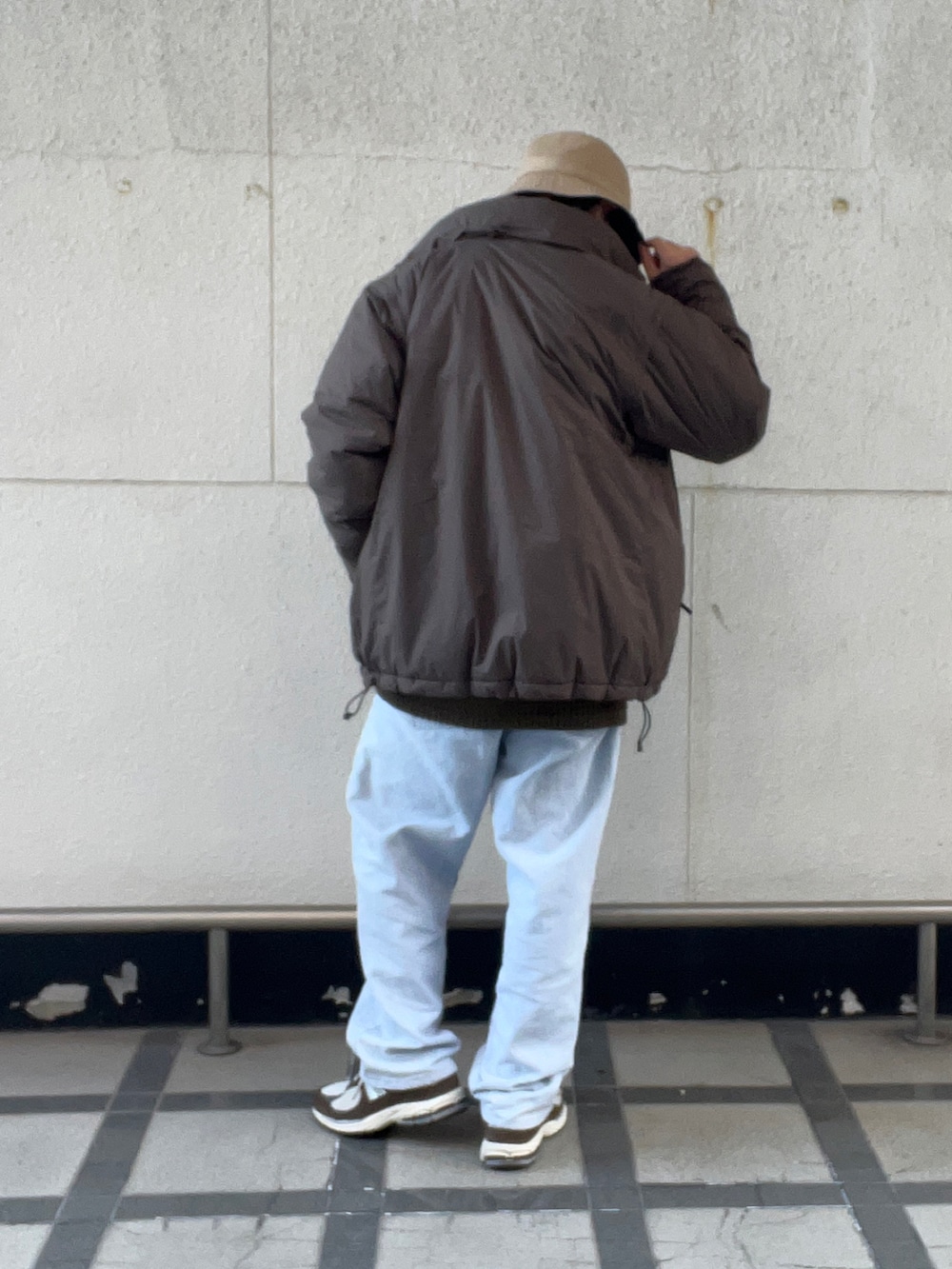 ブラウン系のその他アウター、オレンジ系のニット/セーター、ブルー系のデニムパンツを着用したメンズの冬コーディネートの3枚目の写真