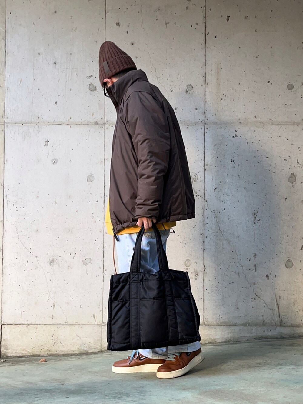 ブラウン系のその他アウター、ブルー系のデニムパンツ、ブラック系のトートバッグを着用したメンズの冬コーディネートの3枚目の写真