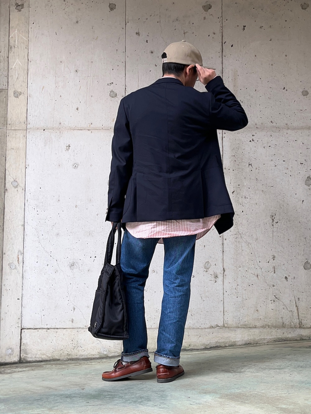 ブルー系のテーラードジャケット、ブルー系のデニムパンツ、ブラック系のトートバッグを着用したメンズの春コーディネートの2枚目の写真