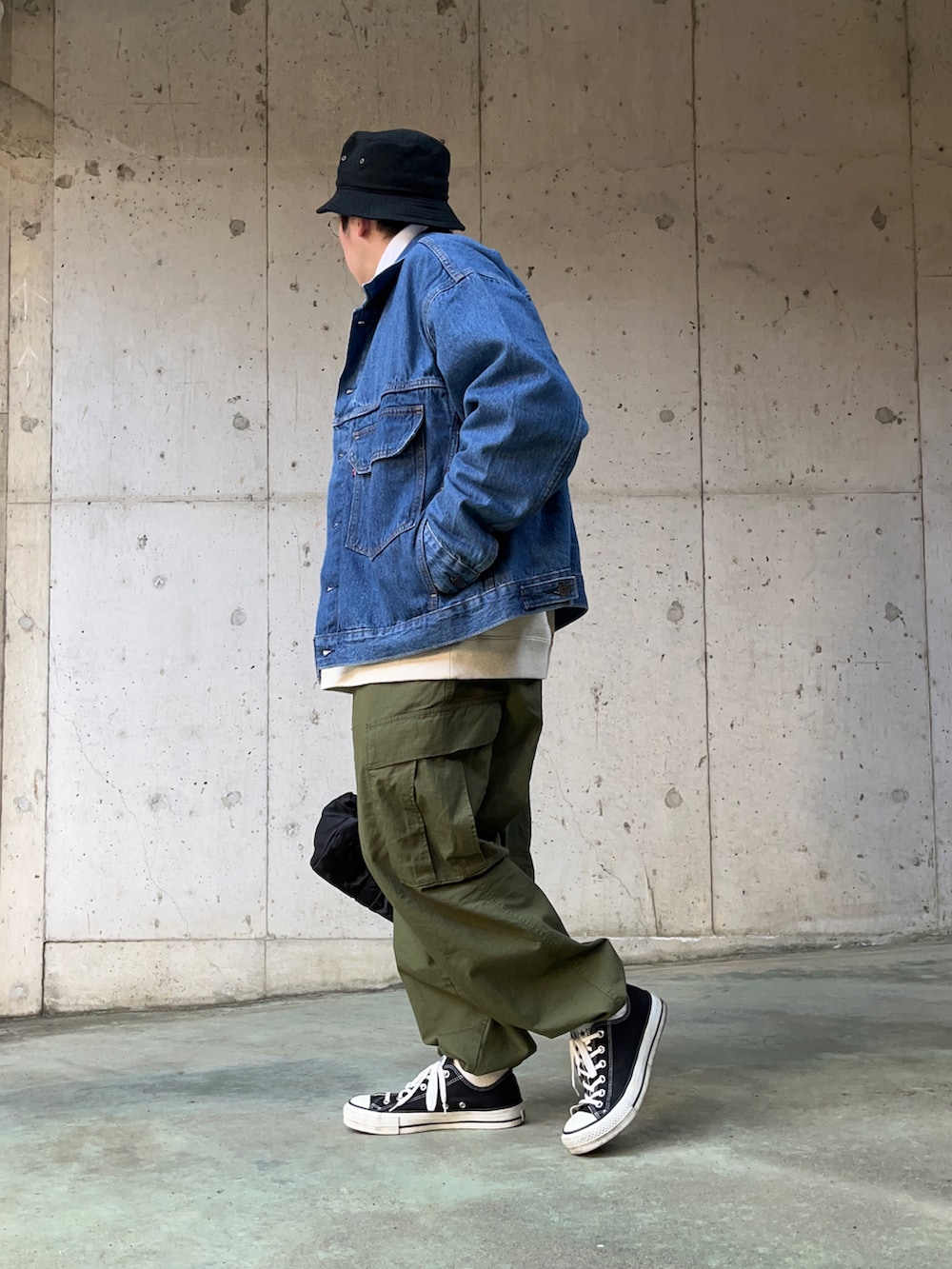 ブルー系のデニムジャケット、グリーン系のカーゴパンツ、ブラック系のボストンバッグを着用したメンズの冬コーディネートの3枚目の写真