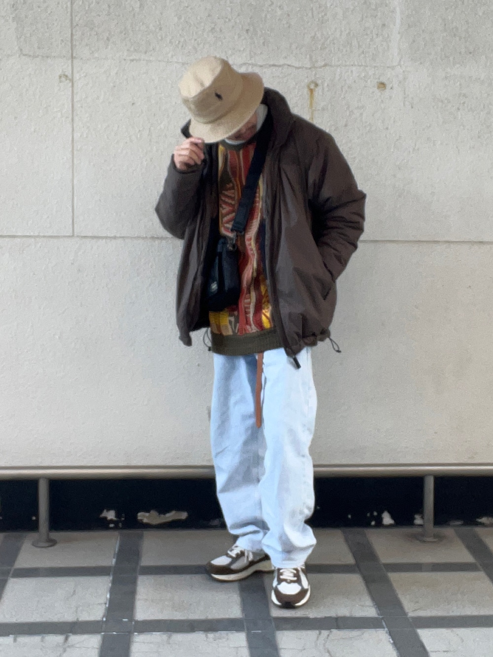 ブラウン系のその他アウター、オレンジ系のニット/セーター、ブルー系のデニムパンツを着用したメンズの冬コーディネートの2枚目の写真