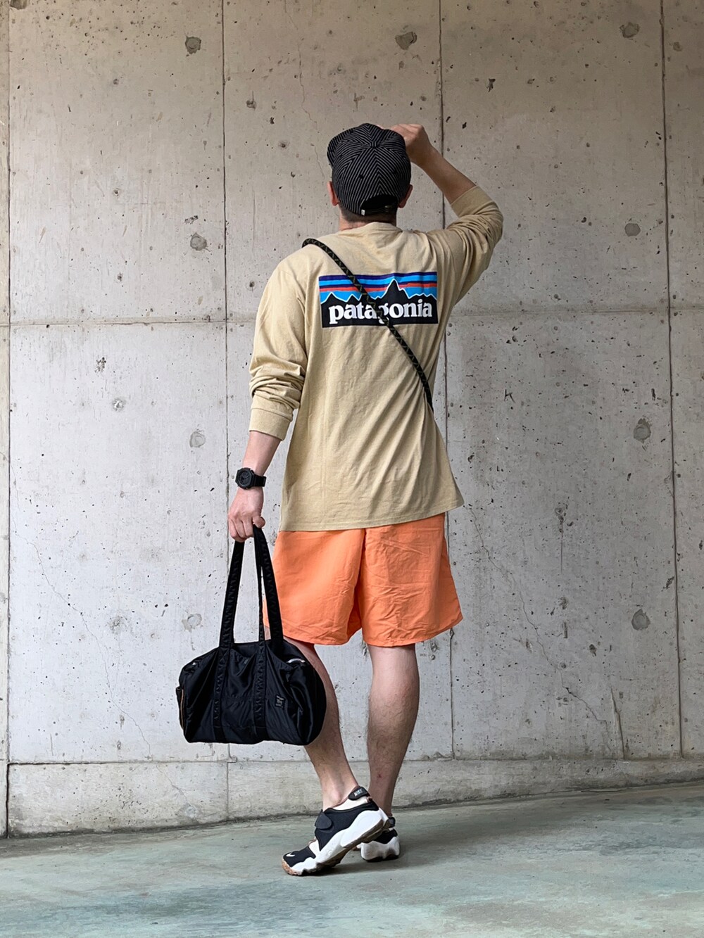 ベージュ系のTシャツ/カットソー、オレンジ系のその他パンツ、ブラック系のボストンバッグを着用したメンズの夏コーディネートの3枚目の写真