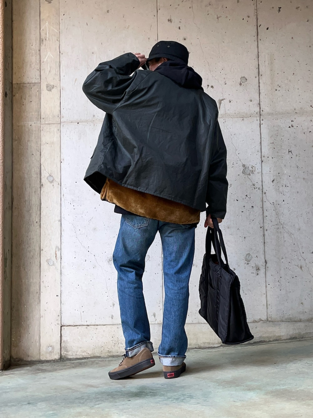 グリーン系のブルゾン、ブラウン系のその他アウター、ブルー系のデニムパンツを着用したメンズの冬コーディネートの2枚目の写真