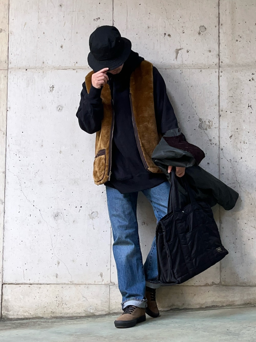 グリーン系のブルゾン、ブラウン系のその他アウター、ブルー系のデニムパンツを着用したメンズの冬コーディネートの3枚目の写真