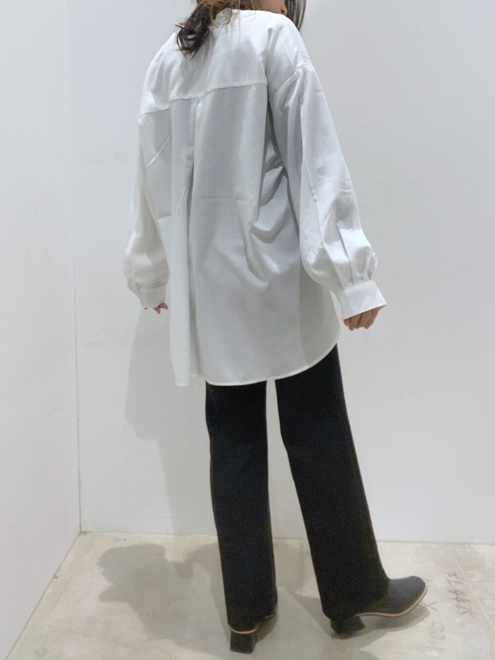 ブラック系のその他パンツ、ブラック系のブーツ、ホワイト系のシャツ/ブラウスを着用したレディースの冬コーディネートの2枚目の写真