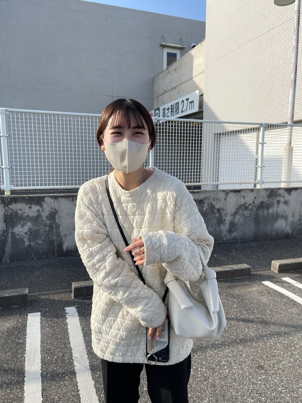 ホワイト系のTシャツ/カットソー、ブラック系のその他パンツ、ベージュ系のハンドバッグを着用したレディースの春コーディネートの2枚目の写真