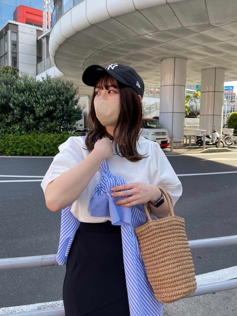 ホワイト系のTシャツ/カットソー、ブラック系のスカート、ブラック系のスニーカーを着用したレディースの春コーディネートの2枚目の写真