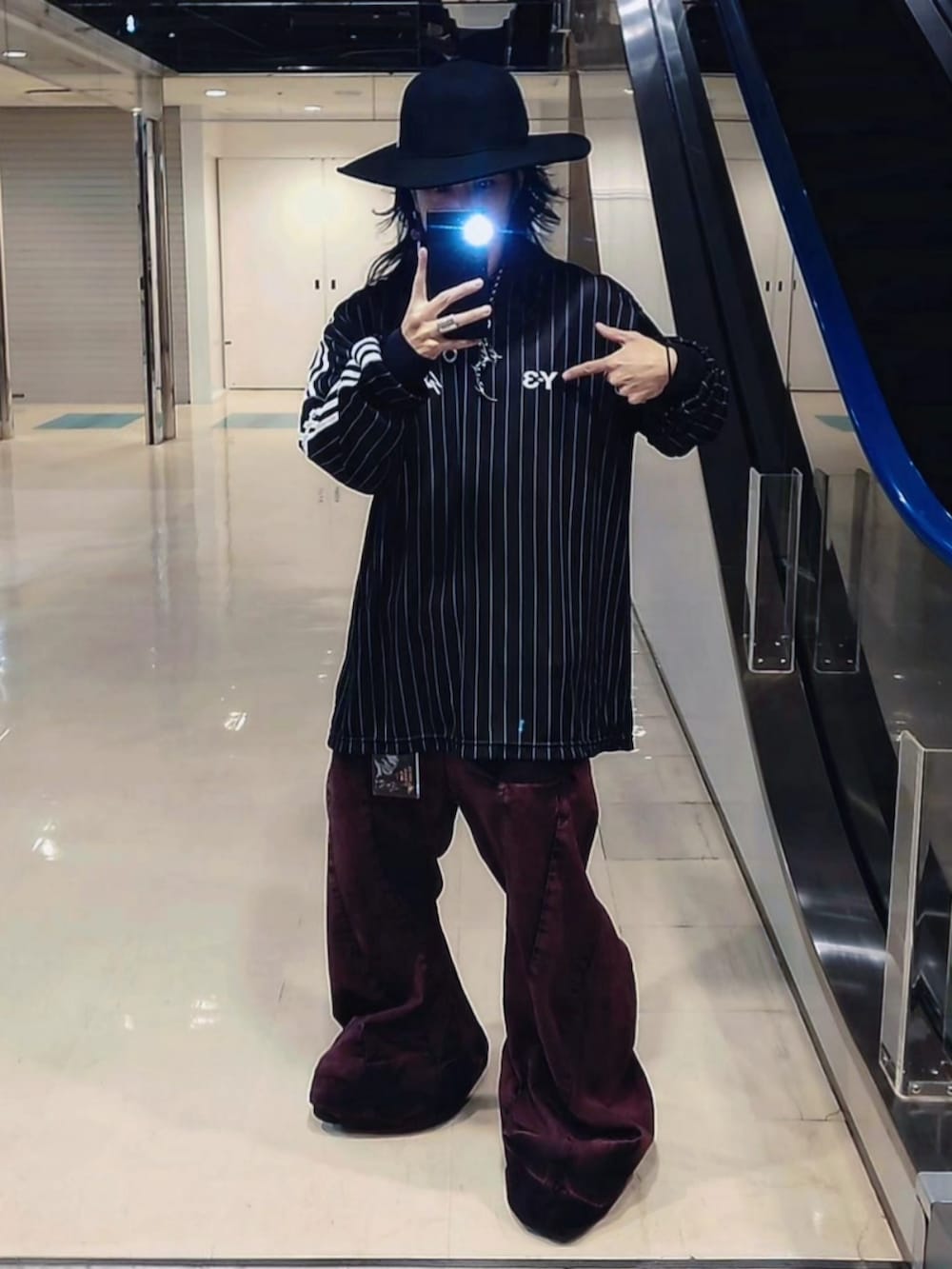 ピンク系のデニムパンツ、ブラック系のジャージ、ブラック系のハットを着用したメンズの春コーディネートの2枚目の写真