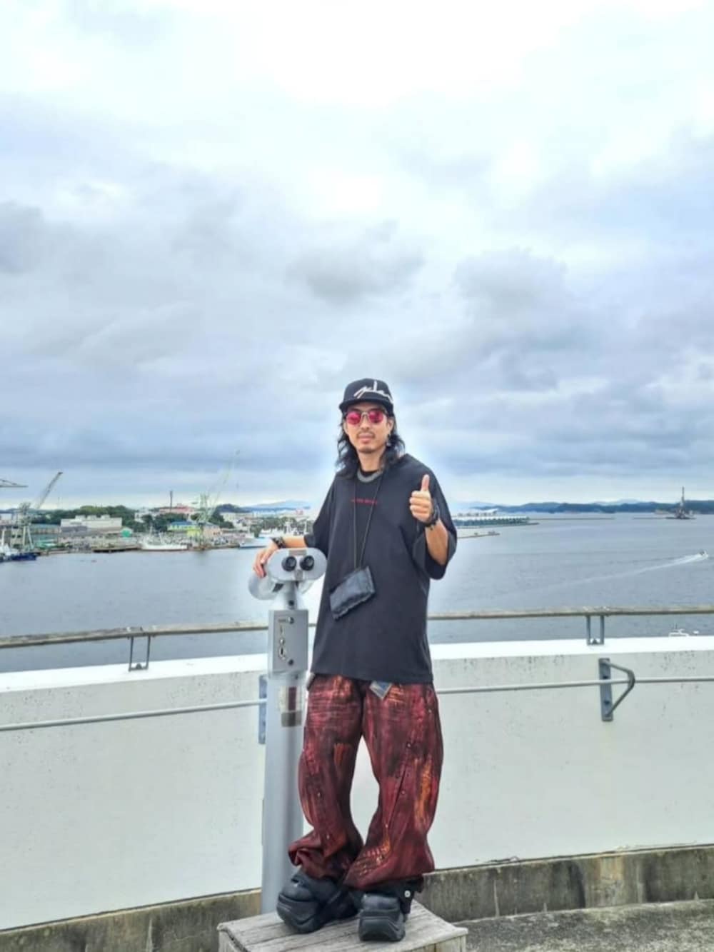 ブラック系のTシャツ/カットソー、レッド系のデニムパンツ、ブラック系のシューズを着用したメンズの秋コーディネートの4枚目の写真