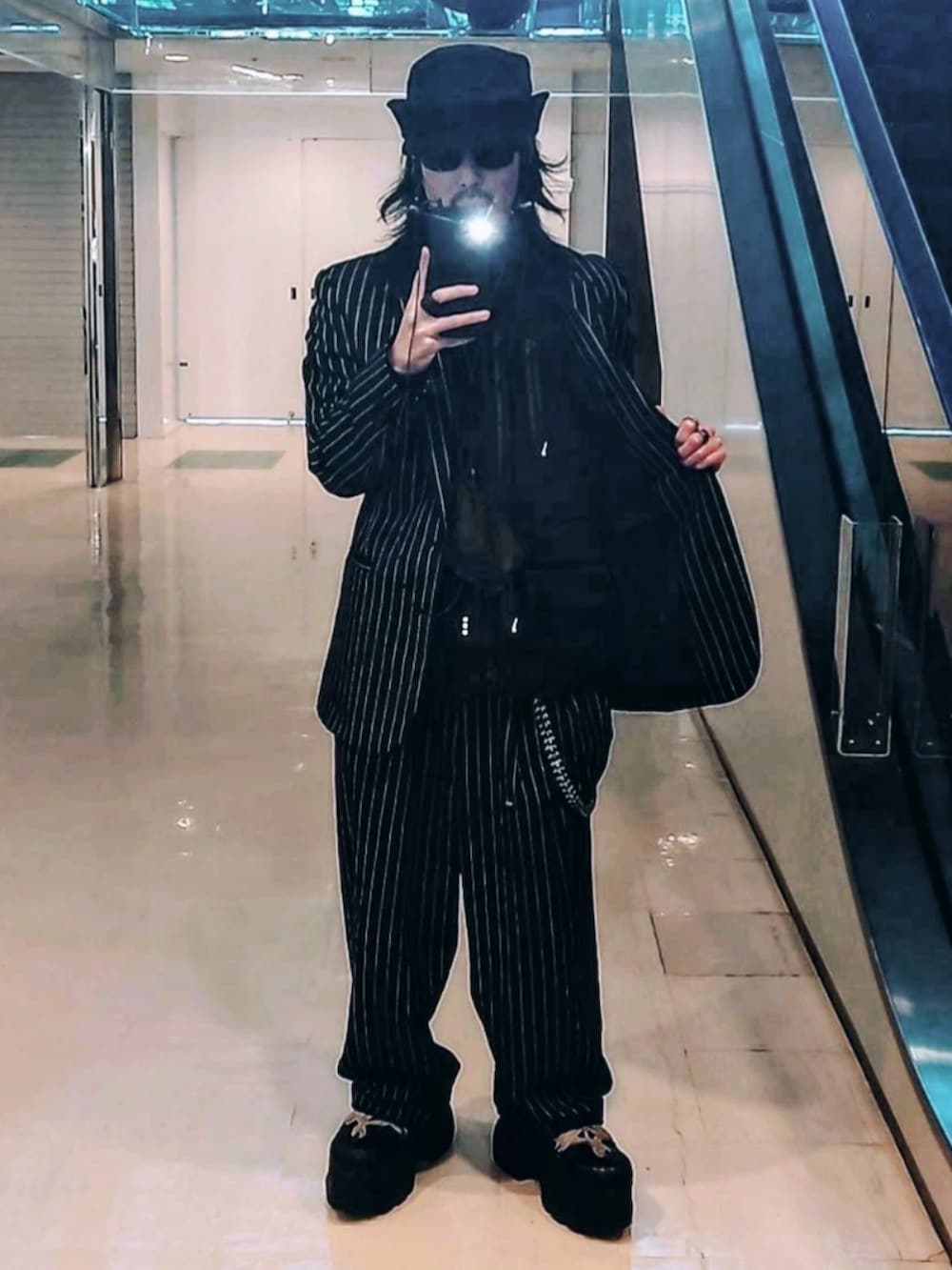 ブラック系のジャケット/アウター、ブラック系のブーツ、ブラック系のスラックスを着用したメンズの春コーディネートの2枚目の写真